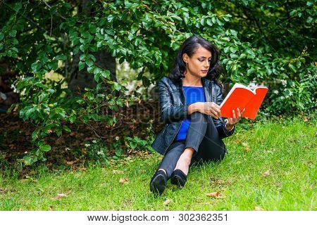 Young American Woman Traveling, Relaxing At Central Park, New York City, Wearing Black Leather Jacke
