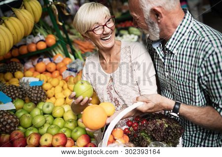 Shopping, Food, Sale, Consumerism And People Concept - Happy Senior Couple Buying Fresh Food