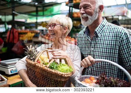 Shopping, Food, Sale, Consumerism And People Concept - Happy Senior Couple Buying Fresh Food