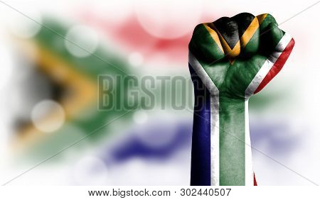 Flag Of South Africa Painted On Male Fist, Strength, Power, Concept Of Conflict. On A Blurred Backgr