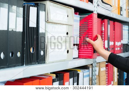 Mans Hand Picking A Blank Blind Folder With Files From The Shelf. Archival, Stacks Of Documents At T