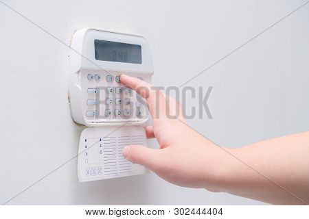 Woman Hand Entering Alarm System Password Of An Apartment, House Of Business Office. Surveillance An