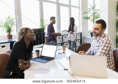 Group Of Business Mixed Race Partners Discussing Strategies At Meeting In Office