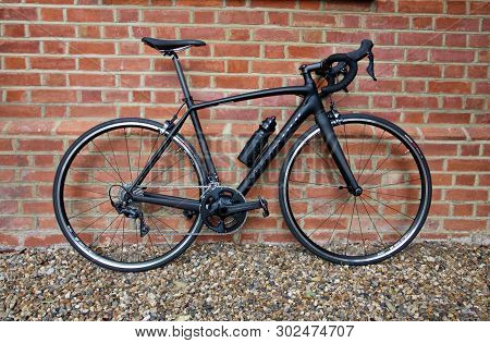 28 April 2019 - London, United Kingdom: Stylish Black Bicycle Standing Against Weathered Brick Wall
