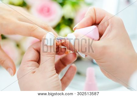 Experienced nail technician applying nail color to fingernails 