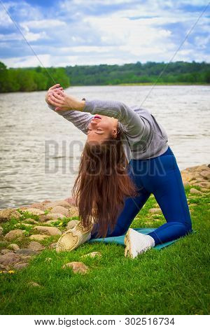 Young Girl Goes In For Sports In Nature. Healthy Lifestyle.flaxible Child Doing Joga Poses Bridge St