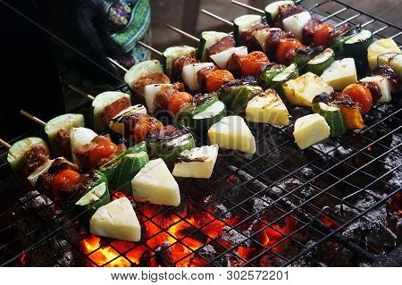 The Selective Focus Pork Barbecue Skewers On Bamboo Sticks With Pineapple, Tomatto, Onion And Chilli
