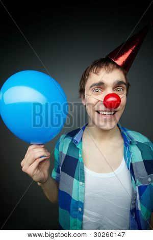 glücklich Kerl hält einen Ballon und verrückt lächelnd in die Kamera feiert FoolÃÂ ¢ Ã?Ã? s Tag