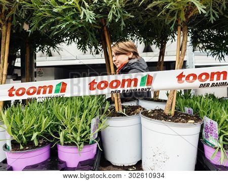 Frankfurt, Germany - Apr 13, 2019: Woman Customer Walking Between Flowers In Pots Outside Toom Der B
