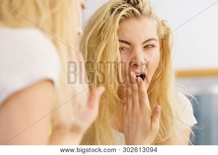 Young Blonde Female Feeling Dull And Tired After Waking Up. Woman Yawning Being Sleepy In Bathroom.