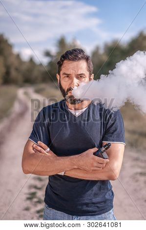 Handsome Smoker Vaping An Electronic Cigarette. Stylish Man.