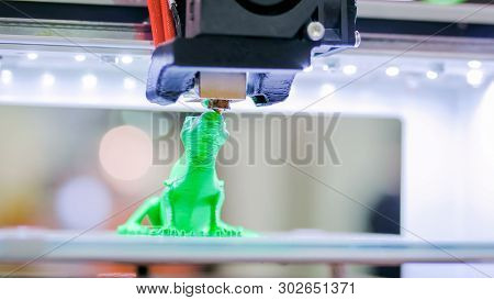 Print Head Of 3d Printer Machine Printing Plastic Model Of Green Toy Lizard At Modern Scifi Technolo
