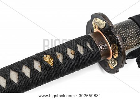 Close-up Tsuka : Handle Of Japanese Sword Wrapped By Black Silk Cord With Gold Fitting Isolated In W