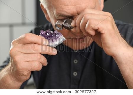 Male Jeweler Evaluating Semi Precious Gemstone In Workshop, Closeup