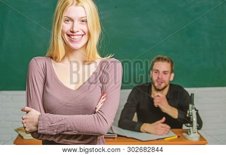 Happy Woman Standing Hands Crossed In Classroom With Teacher. Female Student With Schoolmaster At Ex