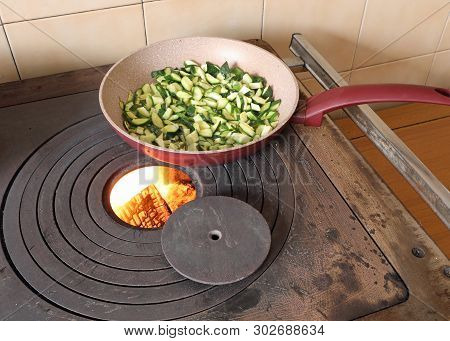 Zucchini In A Pan Are Cooked Over A Wood-burning Stove In A Mountain Hut
