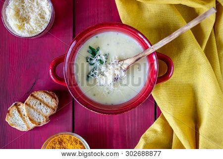 Cheese Cream Soup On A Red Wooden Background. White Bread Croutons. Ingredients.