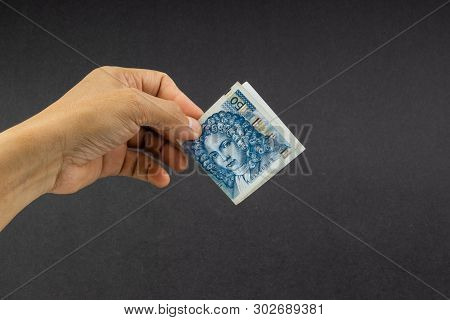 Hand Holding Fifty Croatian Kuna Or Sto Kuna Bank Notes On Black Background. Financial Concept And S