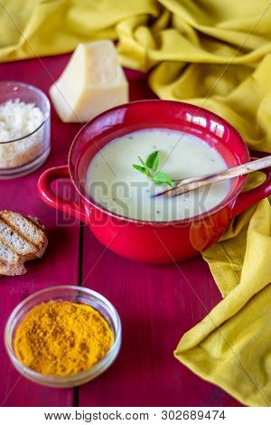 Cheese Cream Soup On A Red Wooden Background. White Bread Croutons. Ingredients.