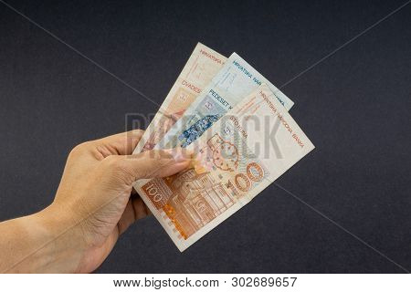 Hand Holding Fifty Croatian Kuna Or Sto Kuna Bank Notes On Black Background. Financial Concept And S