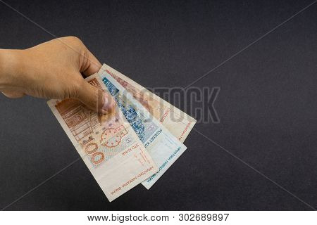 Hand Holding Fifty Croatian Kuna Or Sto Kuna Bank Notes On Black Background. Financial Concept And S