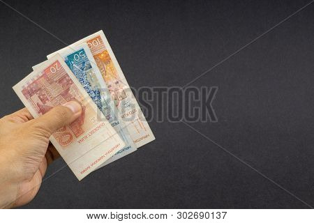 Hand Holding Fifty Croatian Kuna Or Sto Kuna Bank Notes On Black Background. Financial Concept And S