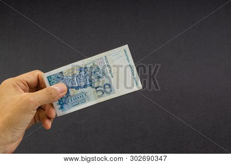 Hand Holding Fifty Croatian Kuna Or Sto Kuna Bank Notes On Black Background. Financial Concept And S