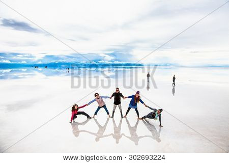 Uyuni, Bolivia- Dec 31, 2018: Group of people make figures with their bodies on the lake Salar de Uyuni, Bolivia. America