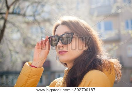 Beautiful Cheerful Girl With Sensual Lips Wearing Sunglasses While Enjoying Spring In The City.