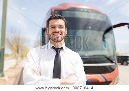 Portrait Of Young Bus Driver Smiling While Standing In Front Of Intercity Bus
