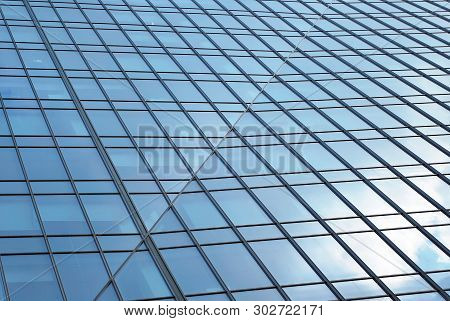 New Office Building In Business Center. Wall Made Of Steel And Glass With Blue Sky.