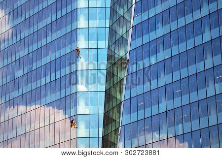 New Office Building In Business Center. Wall Made Of Steel And Glass With Blue Sky.