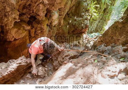 A Woman In Coral T Shirt Walks Down A Rope In A Gorge In The Tropical Jungle. Without Gear