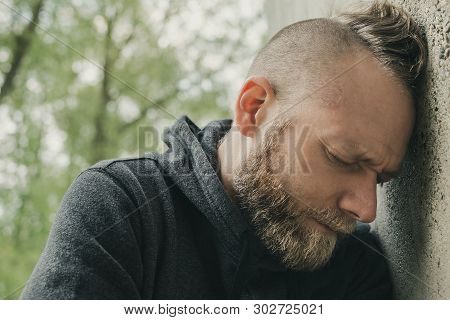 Depressed And Lonely Man His Head Against A Wall