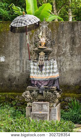 Bedugul, Bali, Indonesia - February 25, 2019: Hindu Shrine In Green Garden Along Road Set Against Gr