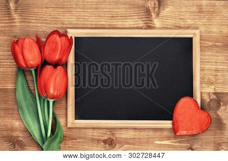 Spring Holiday Background: Blackboard Framed With Red Tulips Onl Wooden Background, Space For Your T