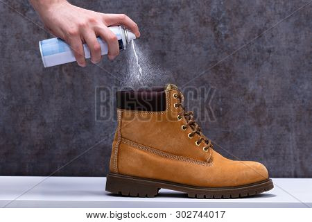 Human Spraying Deodorant On Shoes
