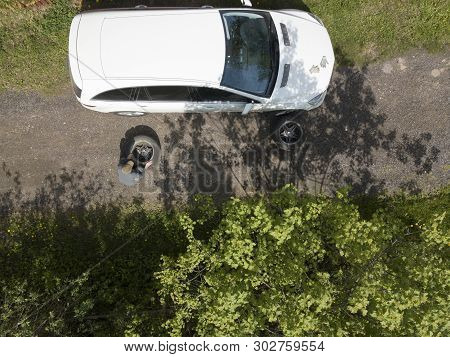 Birds Eye Shot Of A Man Chaging Wheel Of His Vehicle On The Road