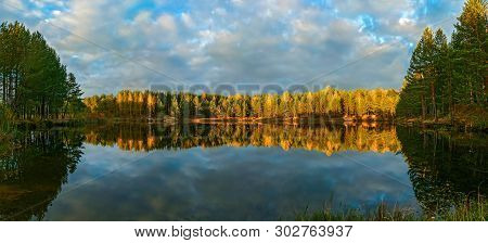 The Forest Lake At Sunset, With Reflection Of Sky And Forest On A Water Smooth Surface, A Panorama F