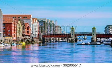 The View Of The Bridge Bakkebru, The River Nidelva  And Historical Old Timber Buildings In Trondheim