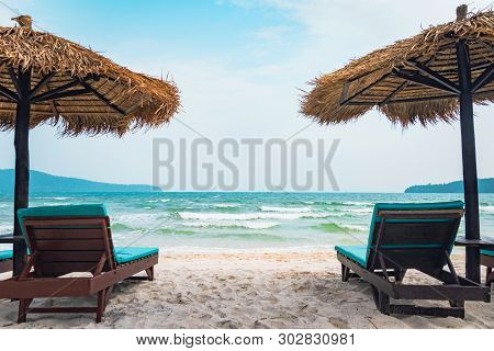 Two Chaise Lounges And Straw Umbrella On Tropical Beach. Coast Of Island Koh Rong Samloem, Cambodia.