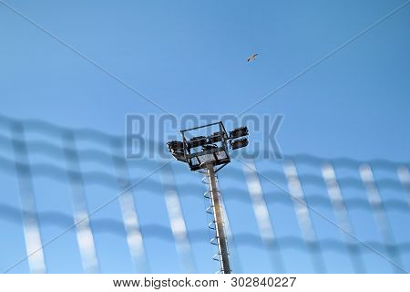 Stadium Floodlight Tower With Reflectors With Blue Sky. Lighting Pole Tower At The Sports Stadium An