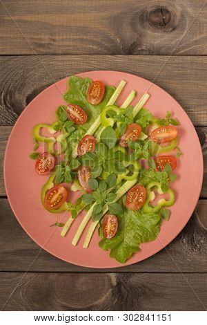 Fresh Raw Vegetable Mix Salad Tomatoes Paprika Cucumbers Basil Letis On A Red Bamboo Plate On A Wood