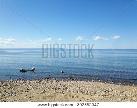 Lake Baikal, The Blue Expanse Of Water And Small Stones On The Shore, A Calm Landscape. The Cleanest