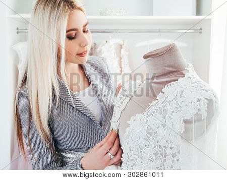 Luxury Boutique. Fashion Consultant Examining Designer Evening Dress From Latest Collection. Trendse