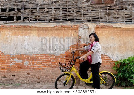Loei, Thailand - February 26, 2018: An Elderly Asian Woman On A Bicycle Ofo Is A Bicycle Sharing Ser