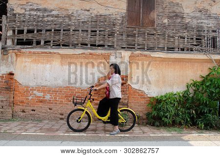 Loei, Thailand - February 26, 2018: An Elderly Asian Woman On A Bicycle Ofo Is A Bicycle Sharing Ser