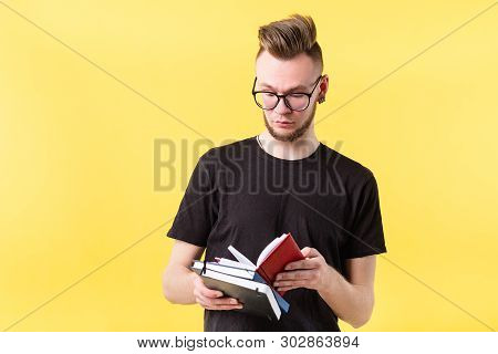 Portrait Of Self Organized, Confident Young Hipster Guy Focused On Reviewing Notes In Pocketbook. Co