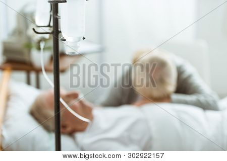 Selective Focus Of Sad Senior Woman With Husband In Coma In Clinic