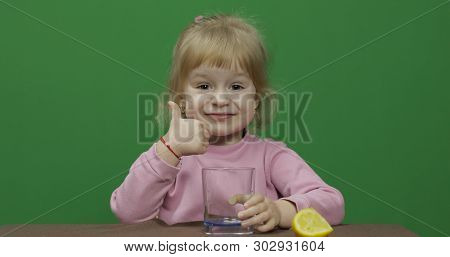 Beautiful Young Girl Eats A Lemon With A Grimace On Her Face. Green Screen. Chroma Key